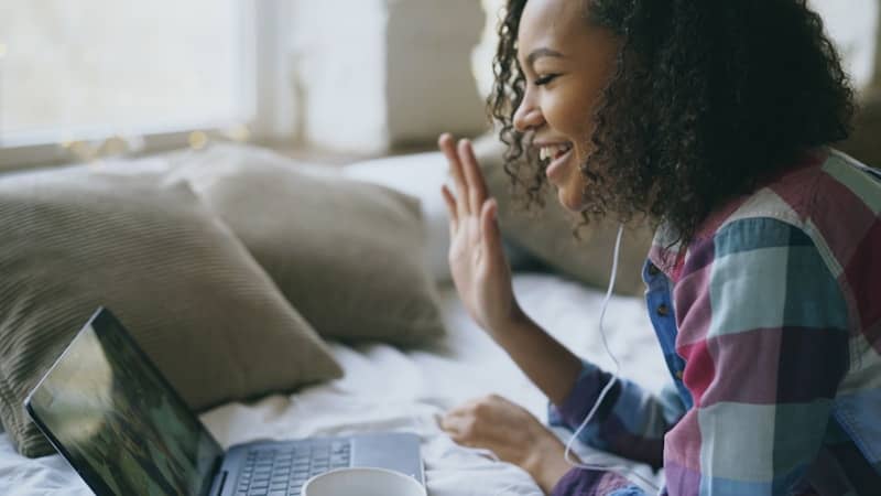 Woman waving at a laptop